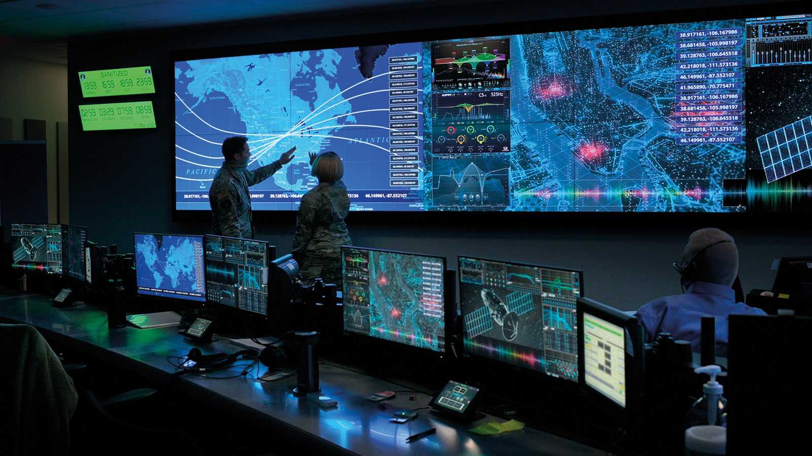Innenansicht des Joint Operations Center des U.S. Space Command. Das Bild zeigt einen hochmodernen Kontrollraum, in dem mehrere Mitarbeiter verschiedene Computerbildschirme überwachen. Die Bildschirme zeigen Echtzeitdaten, Karten, Satellitenortung und Kommunikationsnetzwerke an. Der Raum ist schwach beleuchtet und wird von den blauen und grünen Farbtönen der Monitore erhellt, wodurch eine konzentrierte und technologisch fortschrittliche Atmosphäre entsteht. Die Mitarbeiter sind mit der Überwachung und Steuerung von Weltraumoperationen beschäftigt.